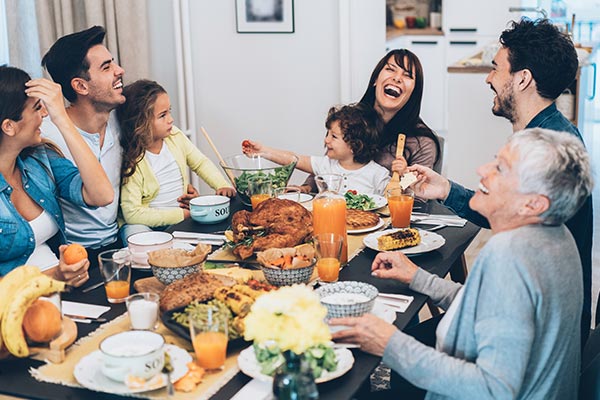 family gathered at thanksgiving dinner laughing and smiling