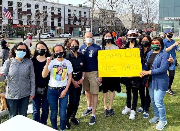 photo of Amy Ko-Tang with a group of people holding a sign that says spread love not hate 