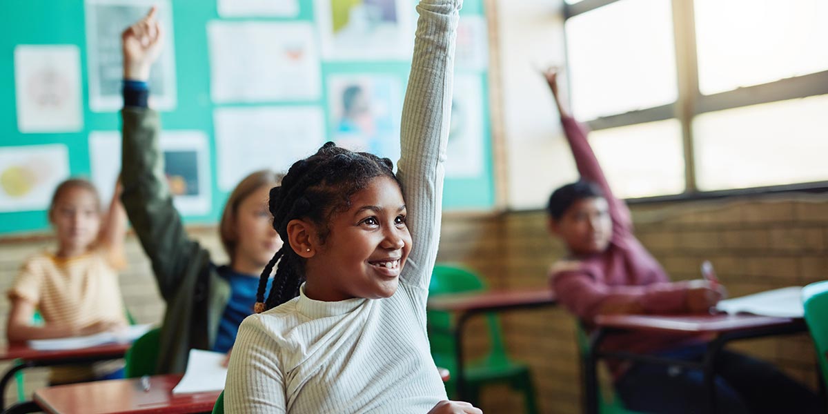 young black student raises her hand in class