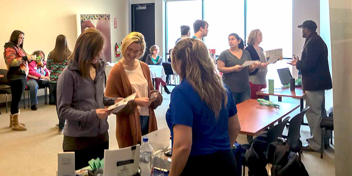 Photo showing group of PASCO employees standing at a table at a training event