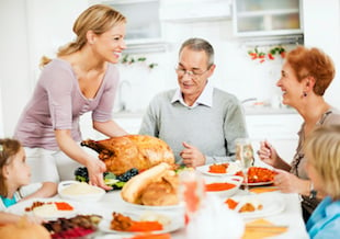 family celebrating thanksgiving table turkey