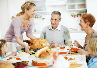 family celebrating thanksgiving table turkey