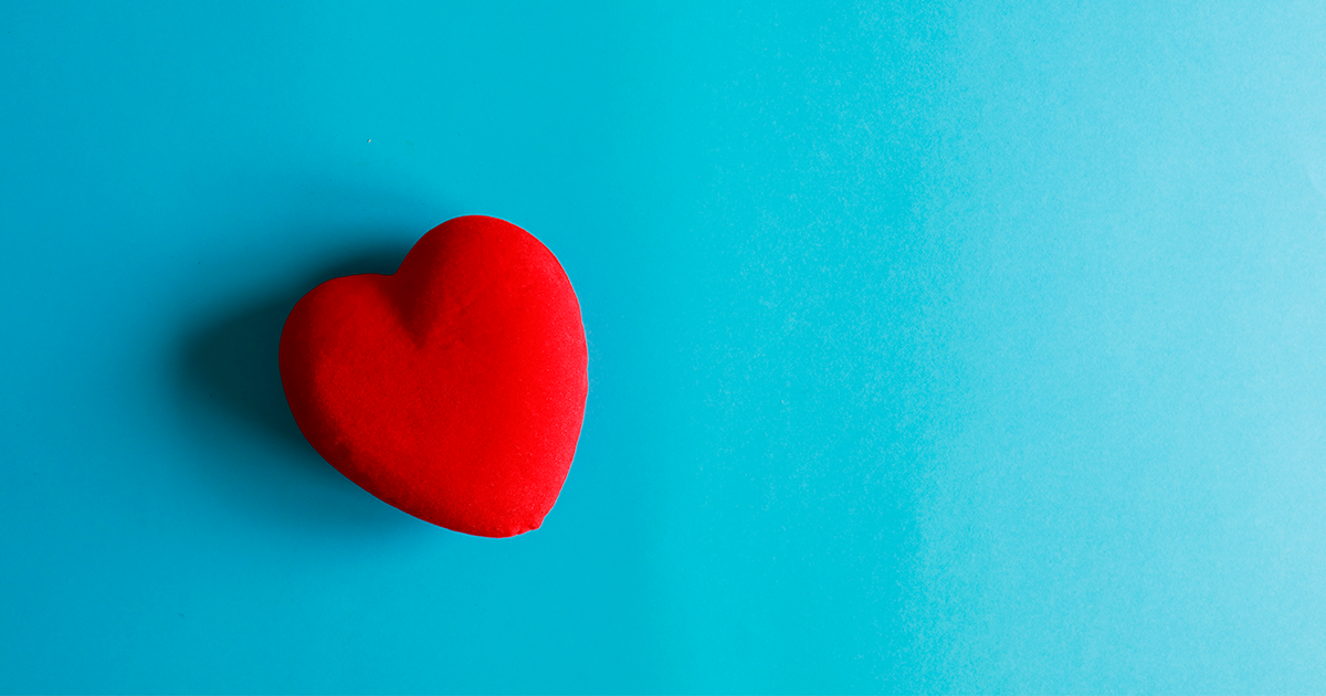 red fabric heart on a bright blue background