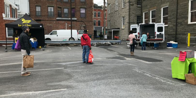 people standing in line six feet apart at kingston farmers market