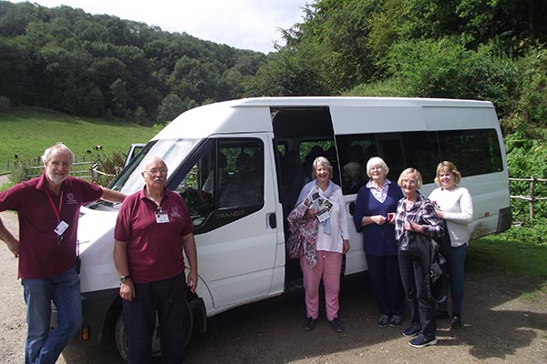 six woodchester mansion volunteers standing in front of new bus