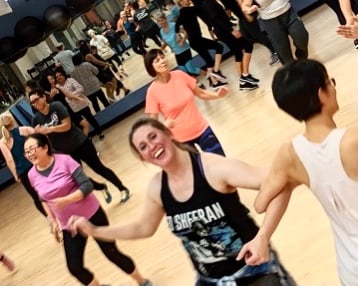 nikki strabala teaching zumba class with a smile on her face