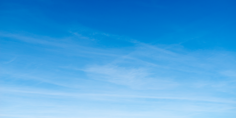 Peaceful blue sky with wispy long clouds.