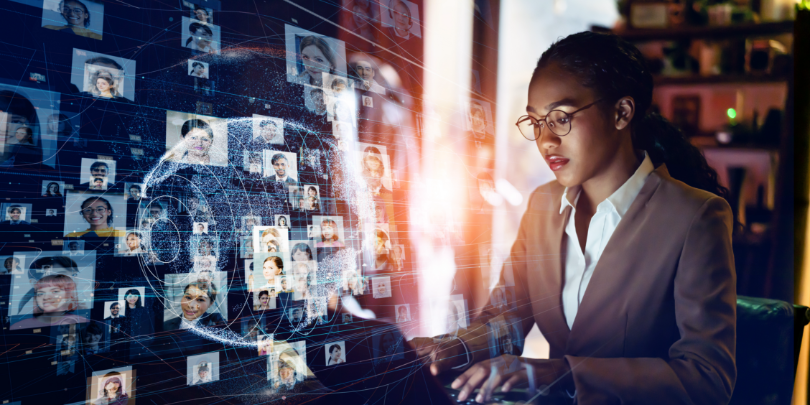 image of woman at a laptop with images of people in a technological world