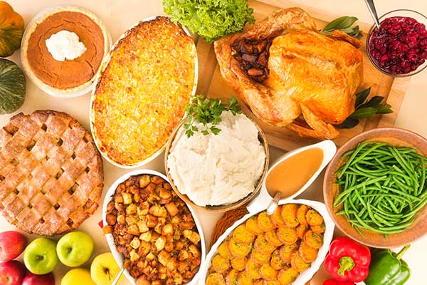 table full of colorful thanksgiving dishes