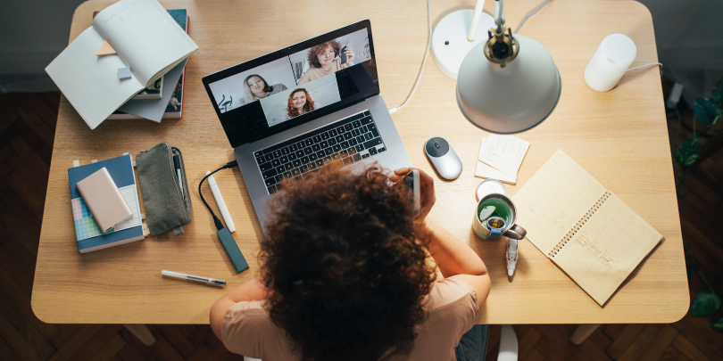 overhead photo of woman working from home desk and on video call