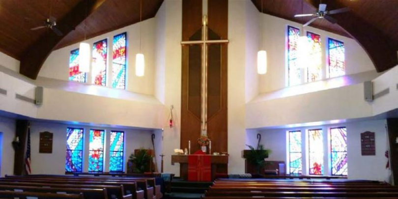photo of the sanctuary at Trinity Lutheran Church with pews and stained glass windows