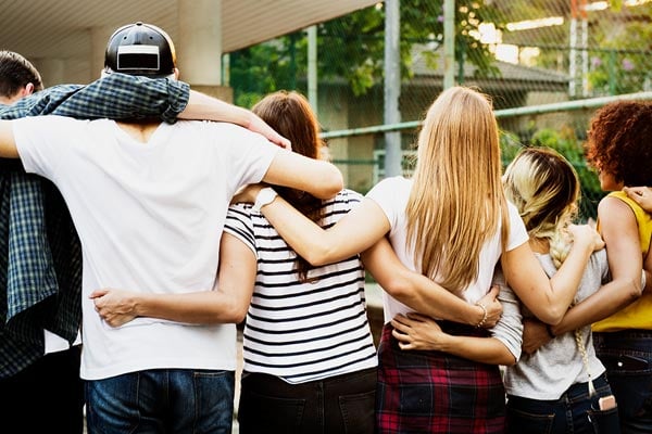 teens with arms around one another