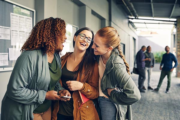 college girls laughing experiencing campus life fun