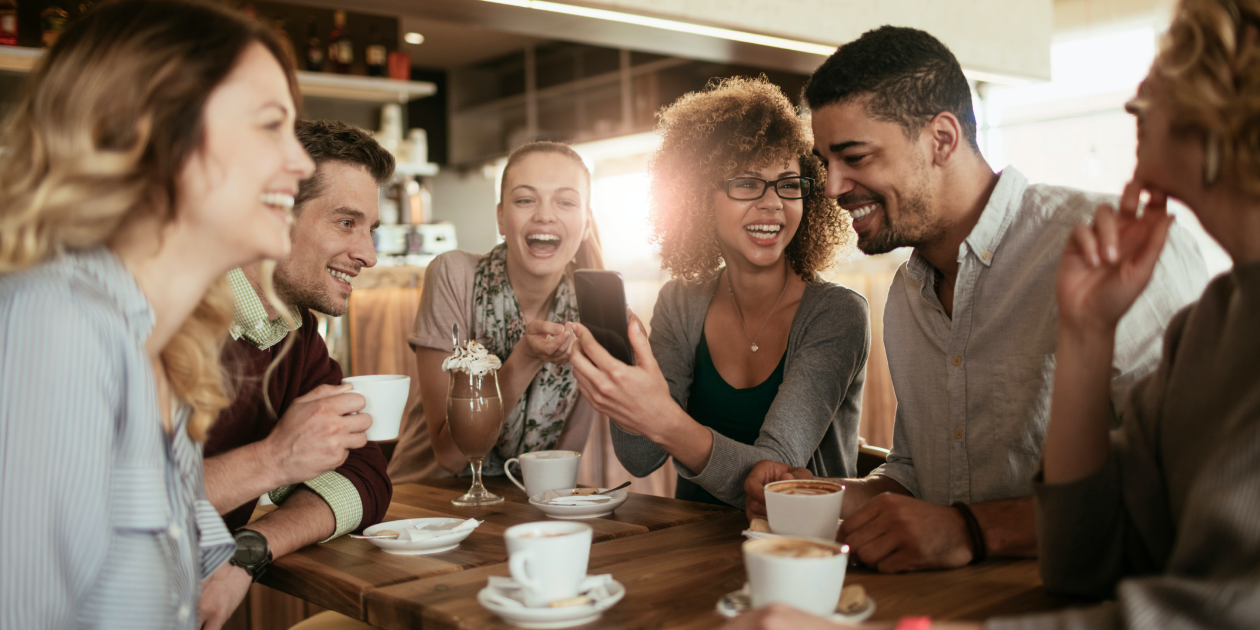 photo of group sitting in a coffee shop laughing