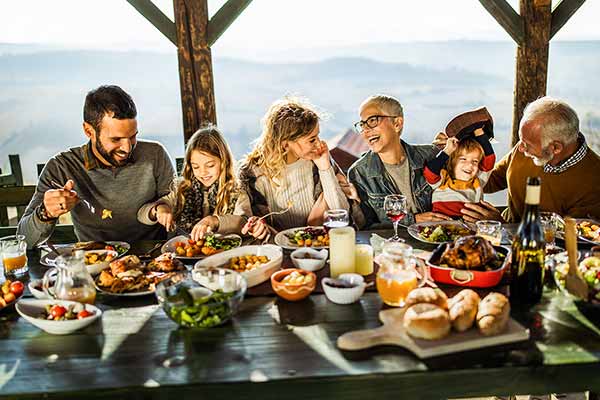 group sitting around table eating food and laughing