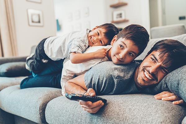 kids on couch watching movie with dad