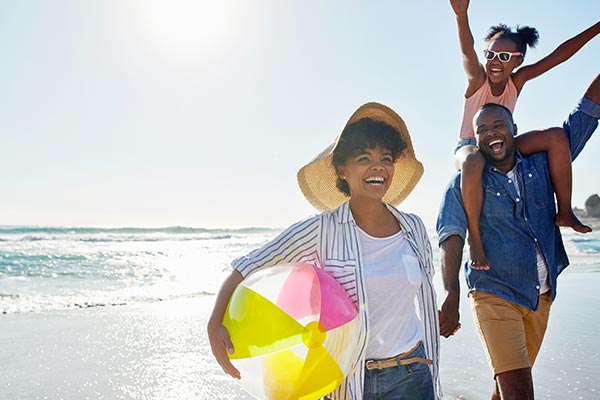 family playing on the beach with beachball