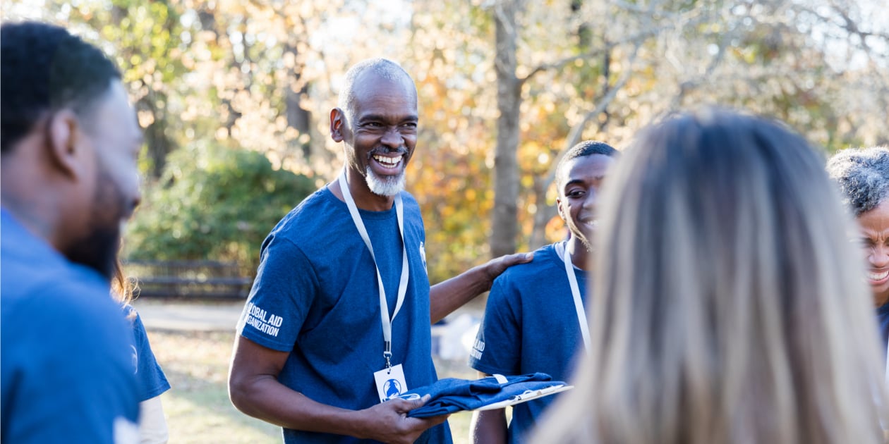 photo of lead volunteer holding a clipboard and talking to group