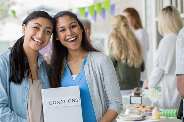 girls holding donation sign for fundraising