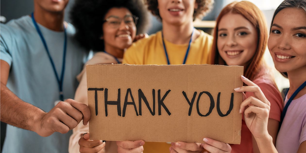 photo of volunteer group holding a sign that says thank you