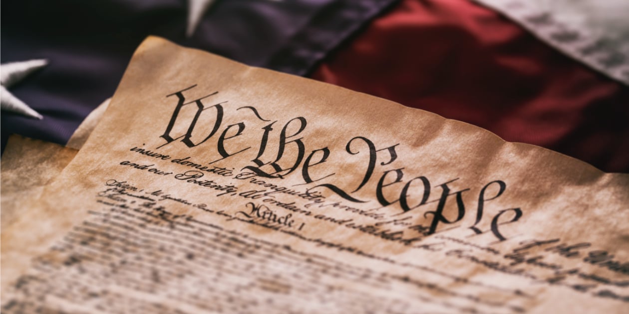 photo of American constitution against the backdrop of a US flag