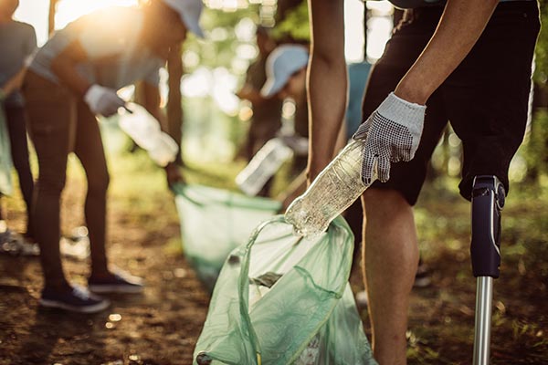 people cleaning up and placing trash in trash bags