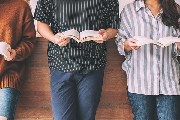 teens standing reading books