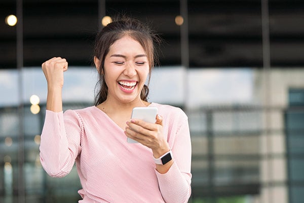 college student girl on phone reading and smiling at message