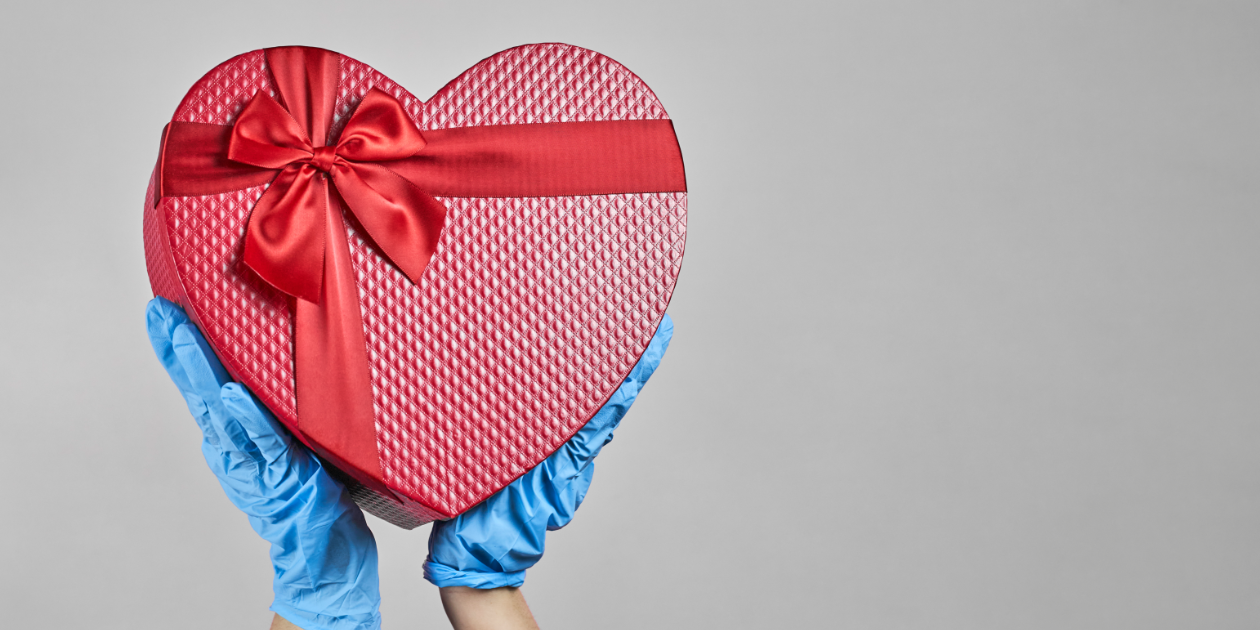 photo of gloved hands holding a heart gift